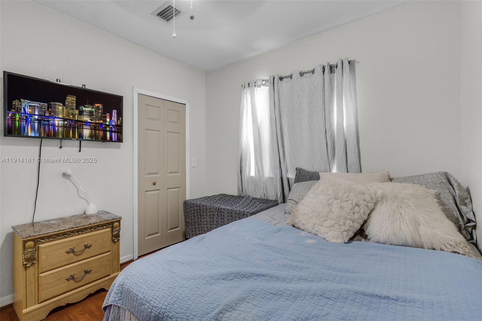 7271 Northwest 174th Terrace, Unit 202 Hialeah, FL 33015 - Photo 18 of 22 a bedroom with a bed and a television