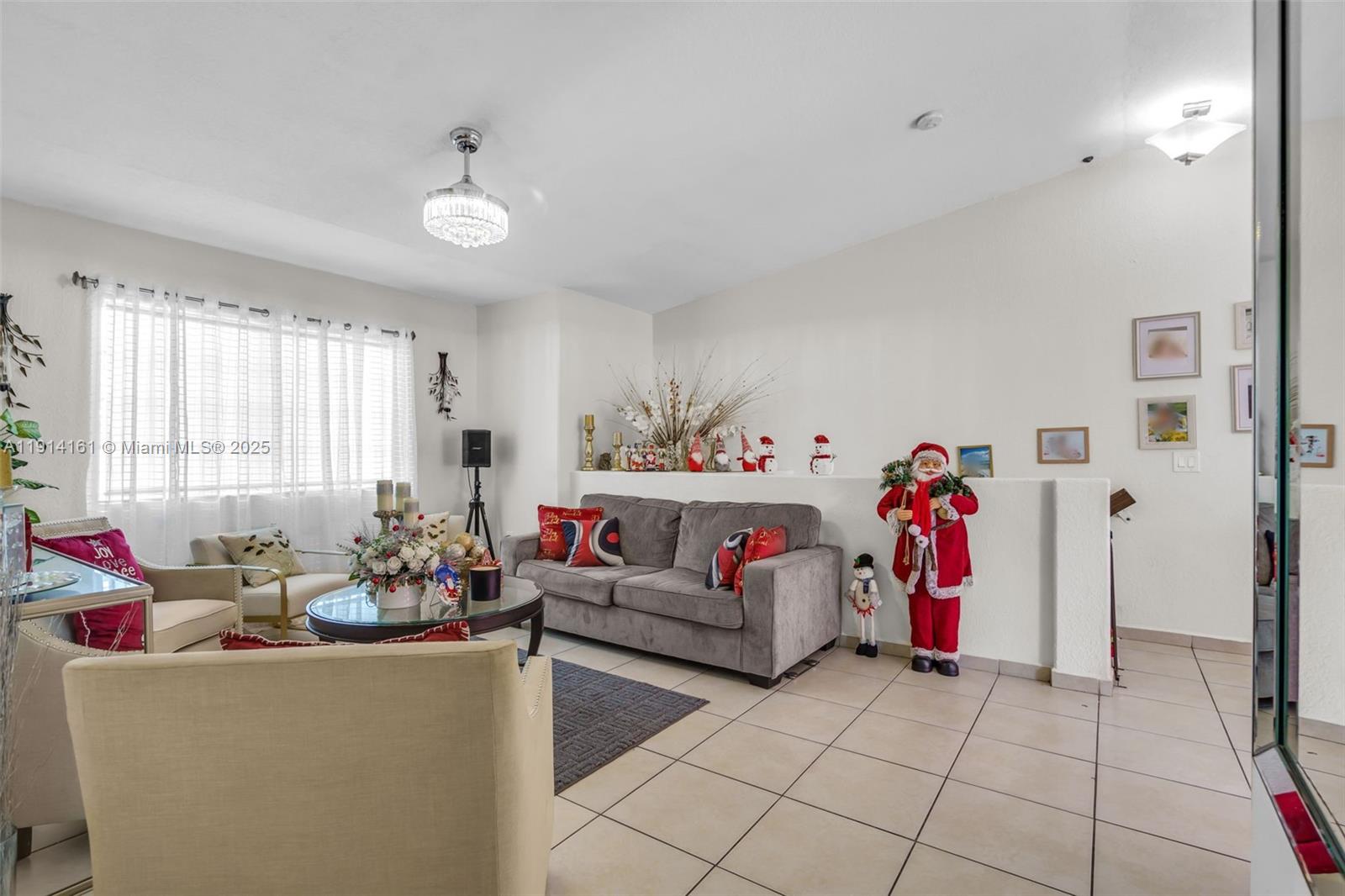 7271 Northwest 174th Terrace, Unit 202 Hialeah, FL 33015 - Photo 4 of 22 a living room with furniture and a chandelier