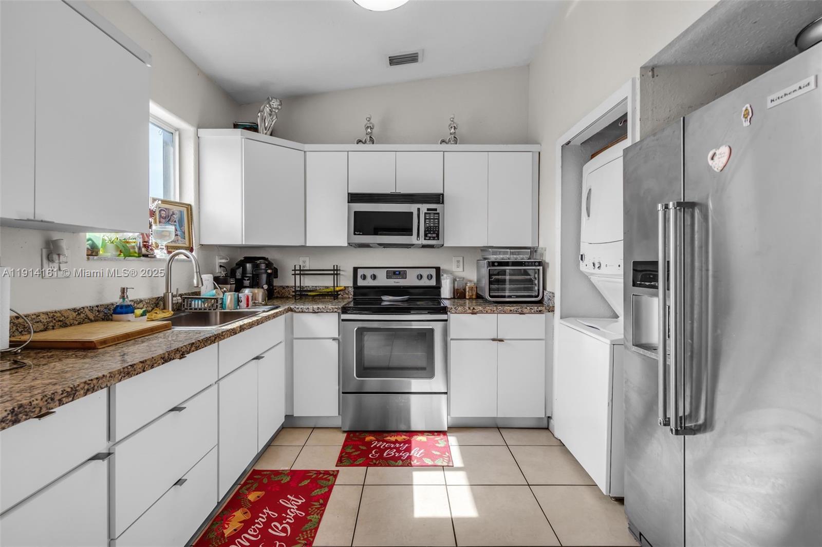 7271 Northwest 174th Terrace, Unit 202 Hialeah, FL 33015 - Photo 8 of 22 a kitchen with a refrigerator sink and microwave