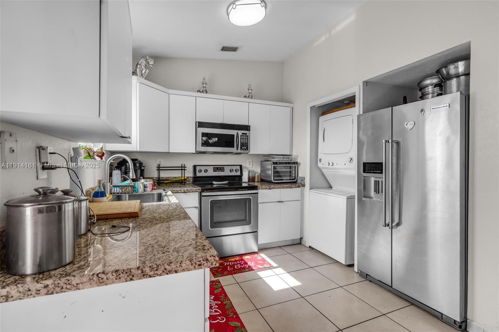 7271 Northwest 174th Terrace, Unit 202 Hialeah, FL 33015 - Photo 9 of 22 a kitchen with stainless steel appliances granite countertop a refrigerator stove and sink