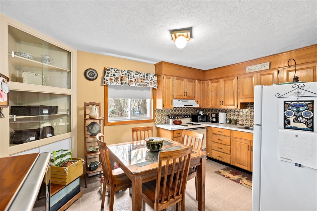 38 Jacqueline Road, Unit B Waltham, MA 02452 - Photo 6 of 21 a kitchen with stainless steel appliances granite countertop a stove top oven a sink a dining table and chairs with wooden floor