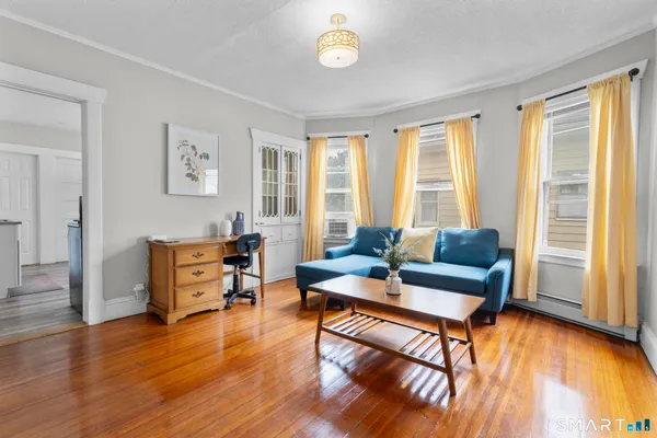 a living room with furniture and a wooden floor