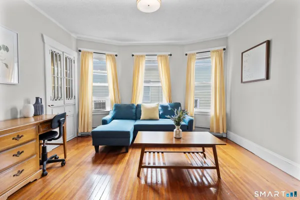 a living room with furniture and a wooden floor