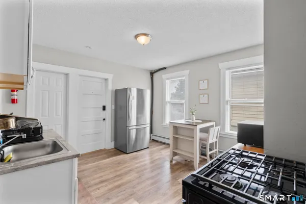 a kitchen with stainless steel appliances a stove a refrigerator and wooden cabinets