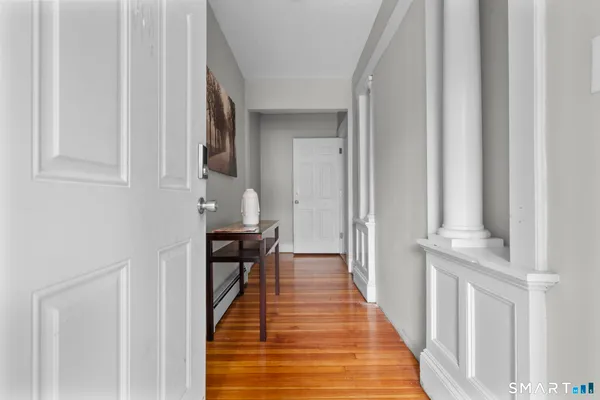 a view of a hallway with wooden floor and staircase