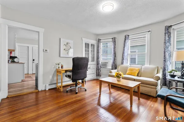 a living room with furniture and a wooden floor