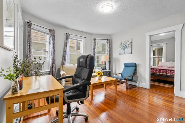 a view of a workspace with furniture and a window