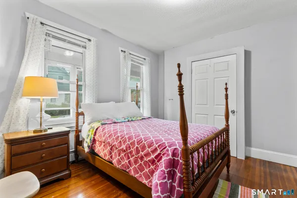 a bedroom with a bed and wooden floor