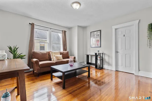 a living room with furniture and wooden floor