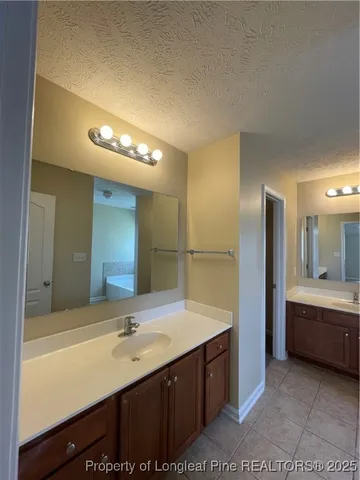 a bathroom with a tub sink and mirror