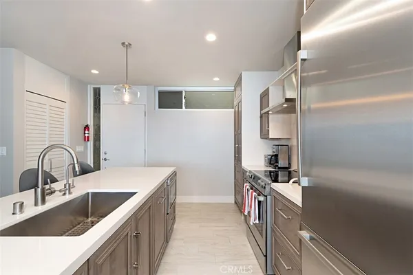 a kitchen with stainless steel appliances kitchen island a sink stove and refrigerator