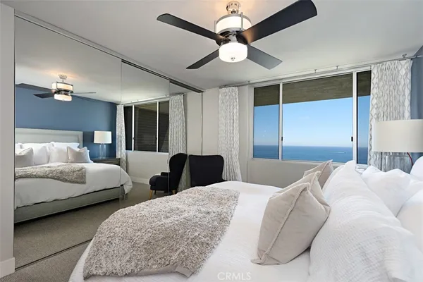 a bedroom with two large bed and a chandelier