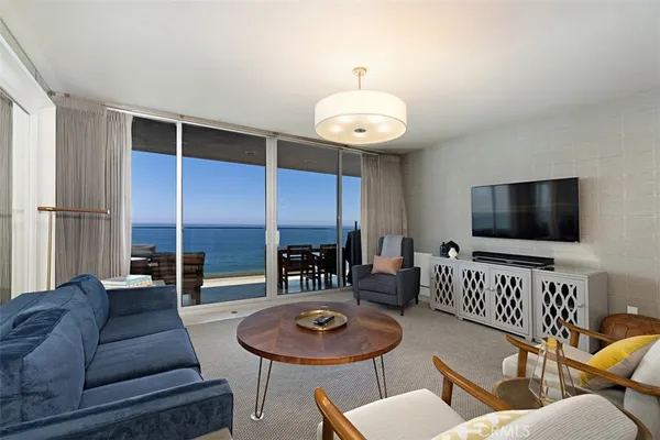 a living room with furniture kitchen and a flat screen tv