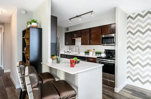 a kitchen with stainless steel appliances a stove a sink and a refrigerator