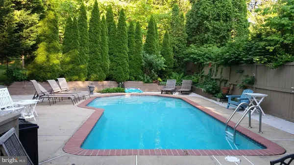 swimming pool view with a seating space