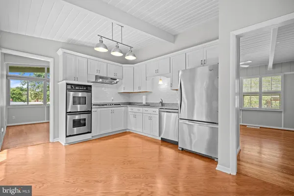 a kitchen with granite countertop a refrigerator and a stove top oven