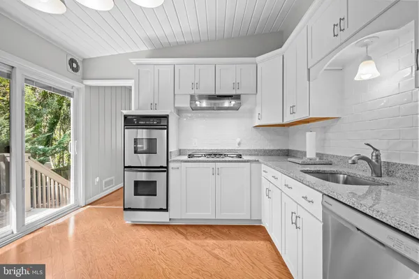 a kitchen with stainless steel appliances granite countertop a refrigerator sink and cabinets