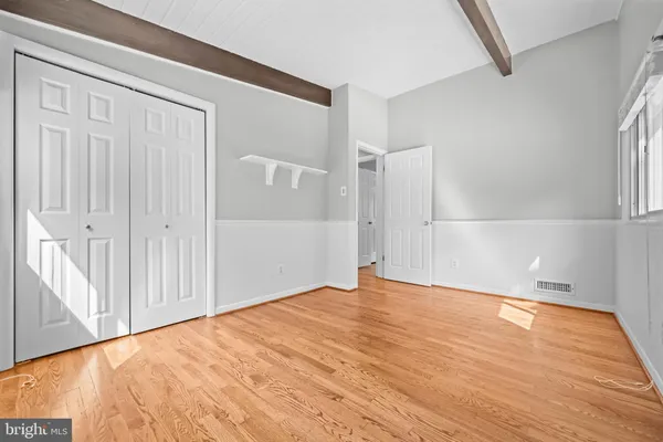 a view of an empty room with wooden floor and entryway