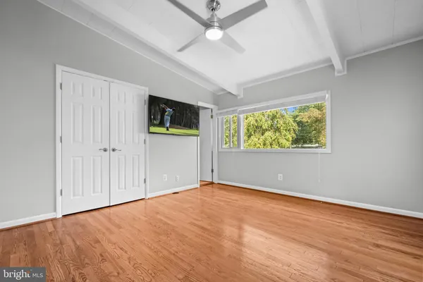 an empty room with window and ceiling fan