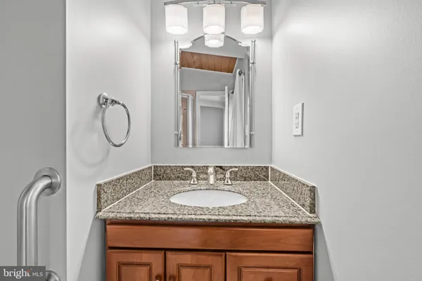 a bathroom with a granite countertop sink and a mirror