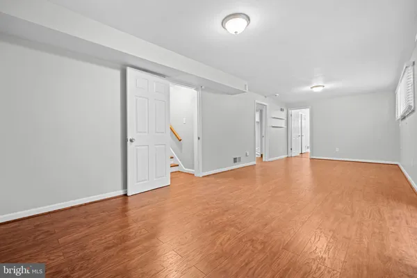 a view of empty room with wooden floor