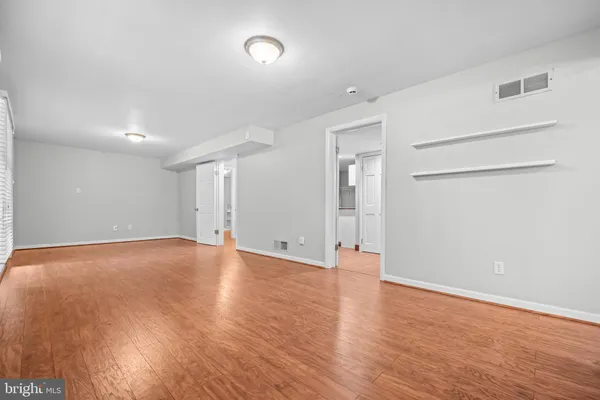 a view of an empty room with wooden floor