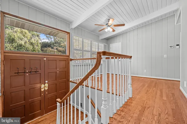 a view of a hallway with wooden floor and staircase