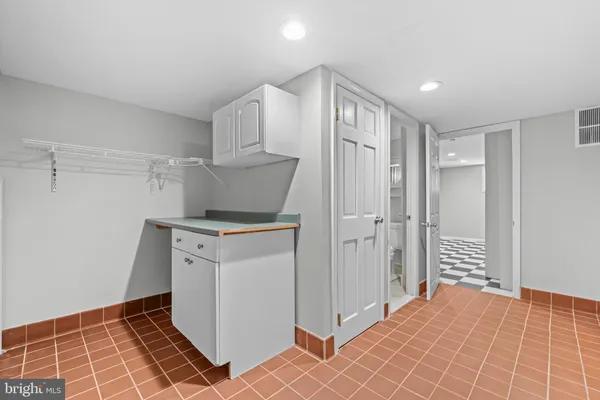 a view of a storage & utility room with closet dryer and window