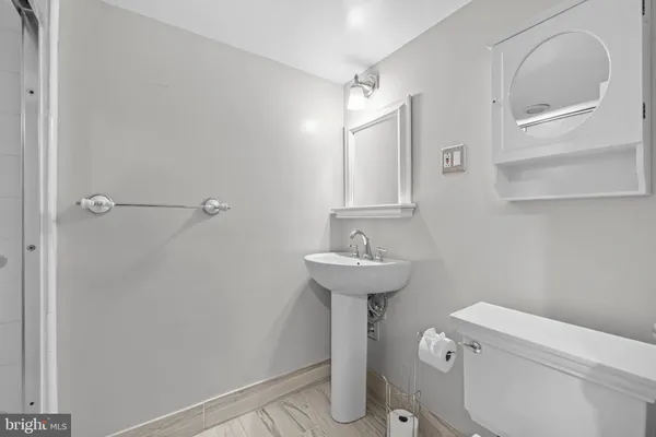 a bathroom with a sink a toilet and a mirror