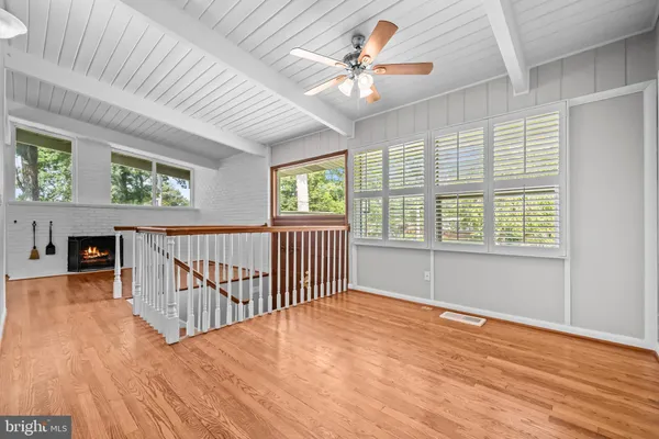 a view of a livingroom with wooden floor and a fireplace