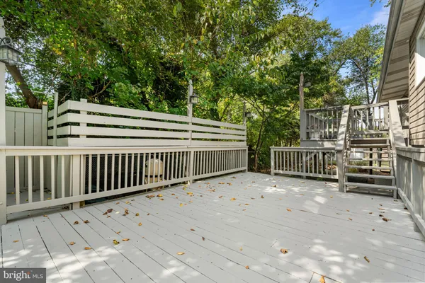 a view of deck with wooden fence and trees