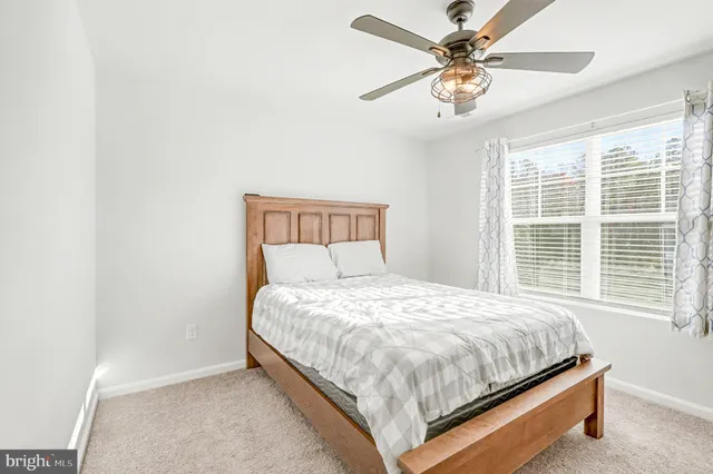 a bed sitting in a bedroom next to a window and a chandelier