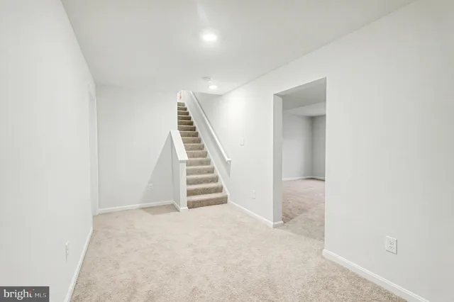 an empty room with a staircase and white walls
