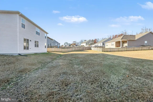 a view of a big house with a big yard and large trees