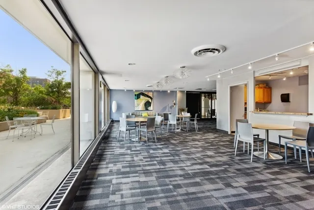 a view of a dining room with furniture one side kitchen view and a large window