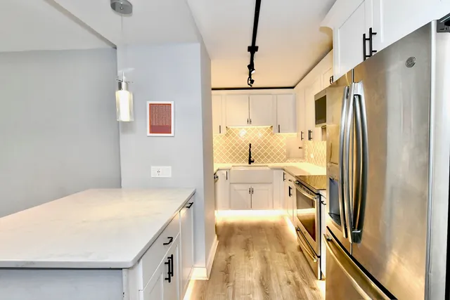 a bathroom with a granite countertop sink a large mirror a shower and a bathtub