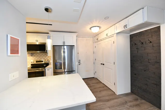 a large white kitchen with a stove and a refrigerator