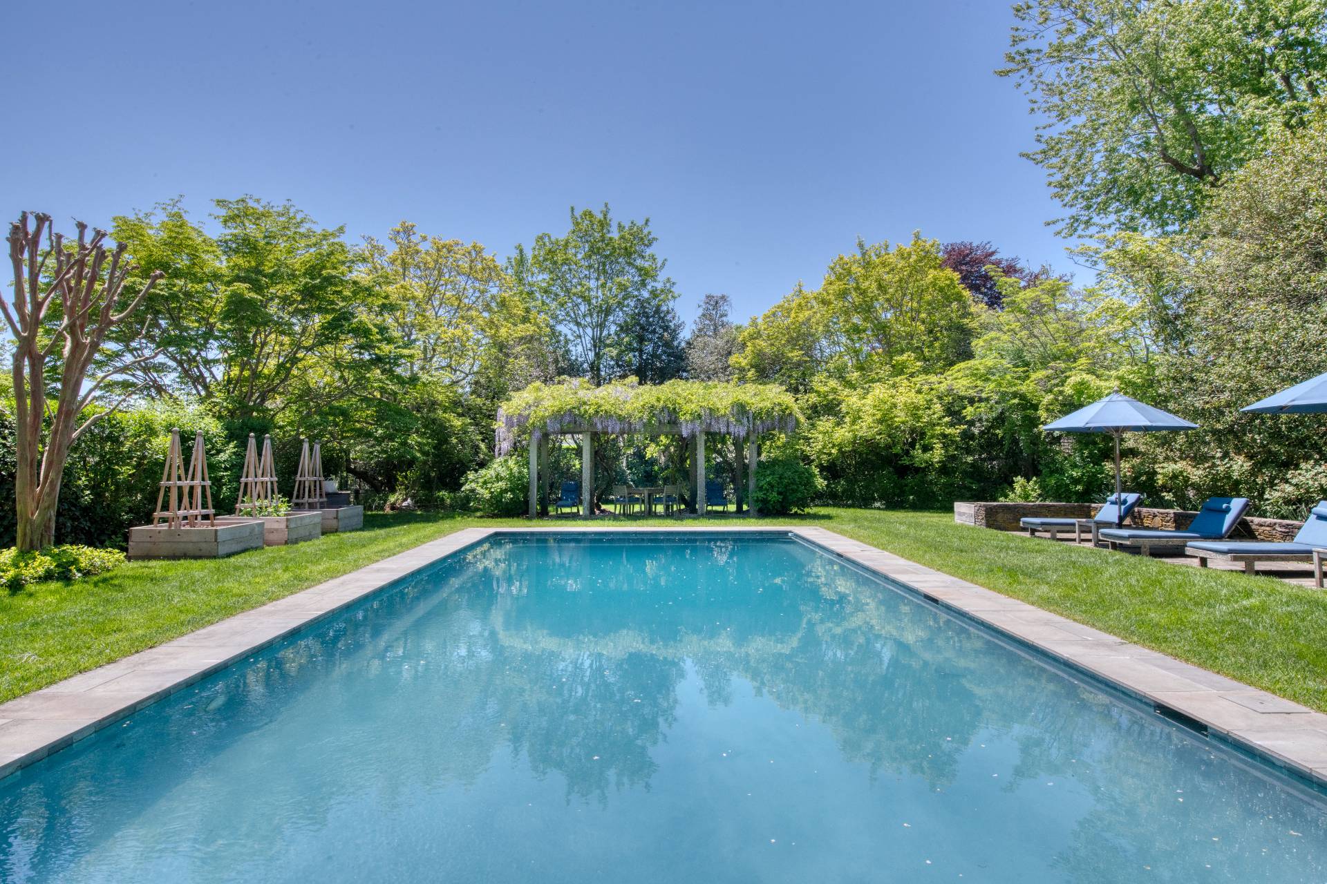 46 Westminster Road Water Mill, NY 11976 - Photo 24 of 28 a view of a swimming pool and trees in the background