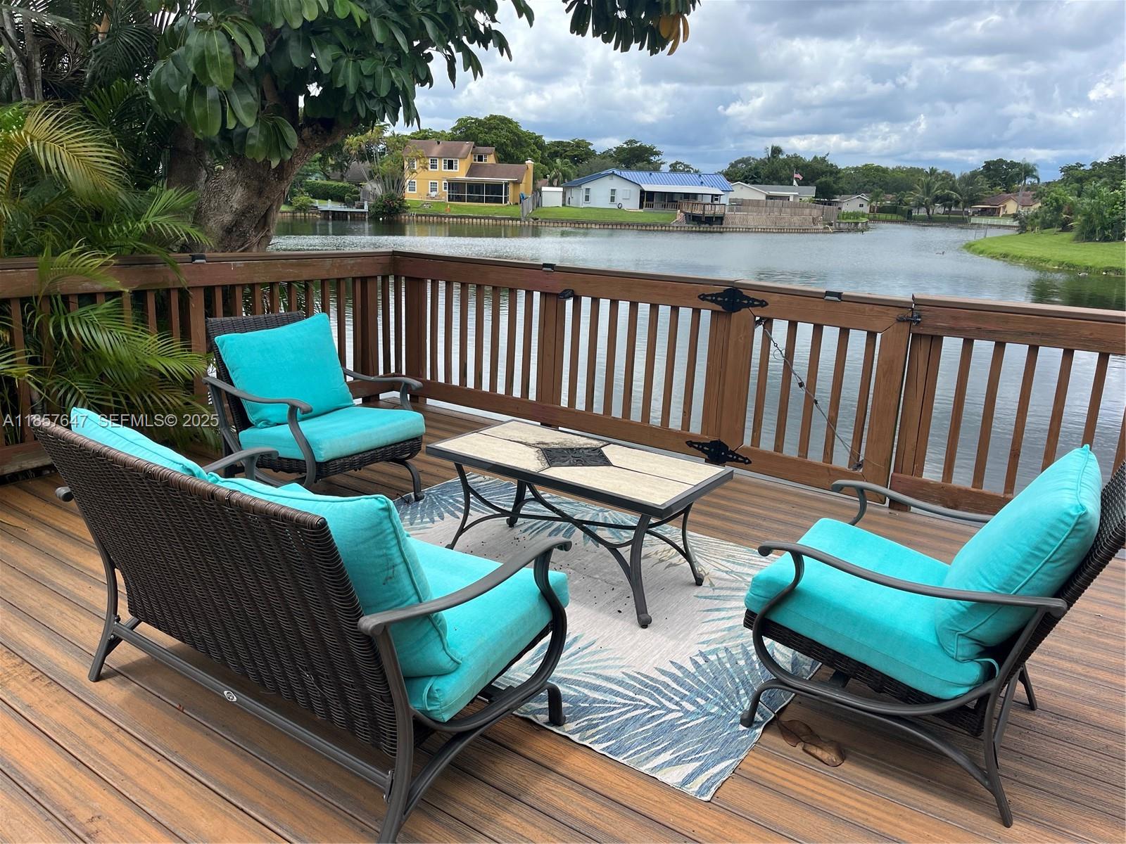 5217 Southwest 87th Avenue Cooper City, FL 33328 - Photo 1 of 8 a balcony with wooden floor and outdoor seating
