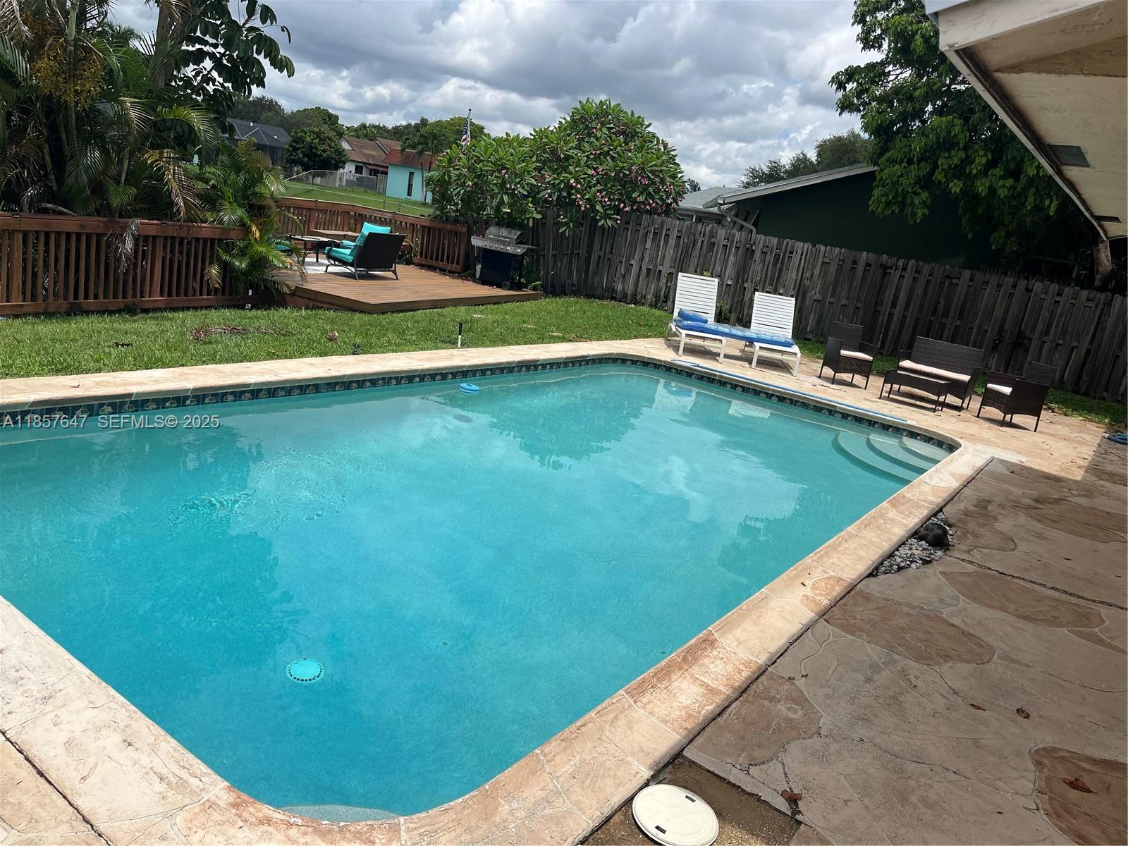 5217 Southwest 87th Avenue Cooper City, FL 33328 - Photo 4 of 8 a view of a swimming pool with a garden