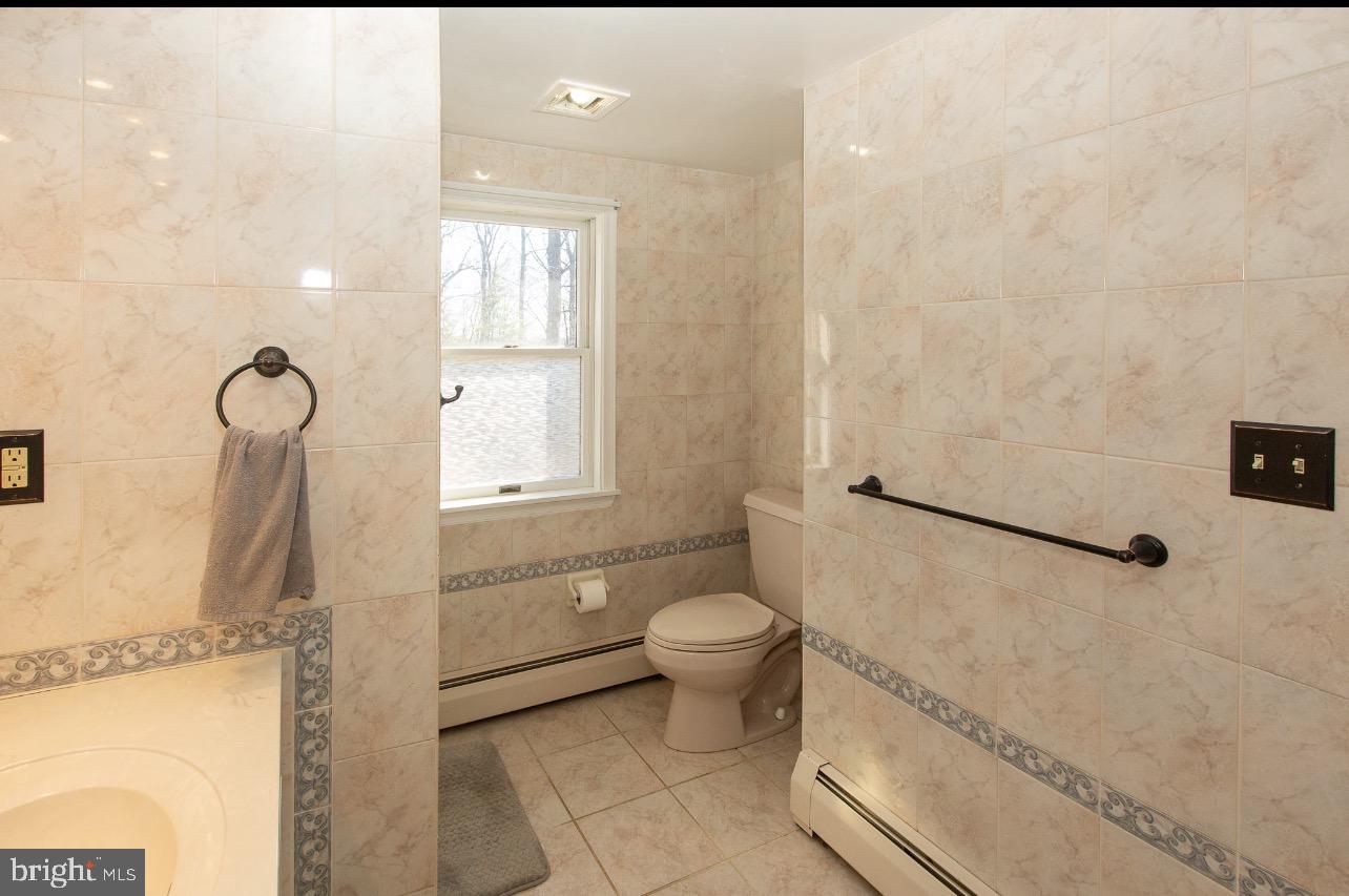 2947 Potshop Road Norristown, PA 19403 - Photo 21 of 41 a bathroom with a granite countertop sink a toilet and a shower