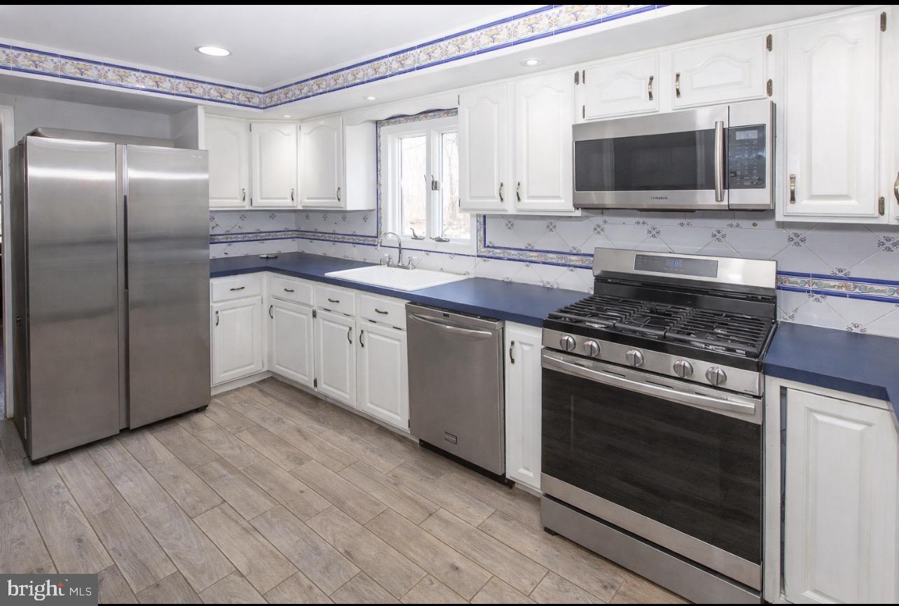 2947 Potshop Road Norristown, PA 19403 - Photo 9 of 41 a kitchen with stainless steel appliances granite countertop a stove a microwave and a refrigerator