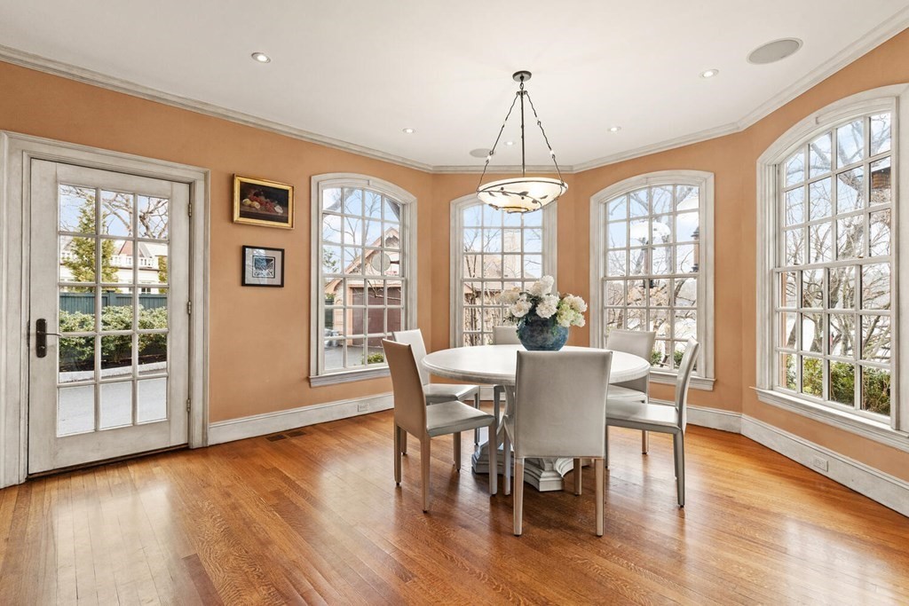 32 Everett Avenue Winchester, MA 01890 - Photo 15 of 42 a dining room with wooden floor a chandelier a glass table and chairs