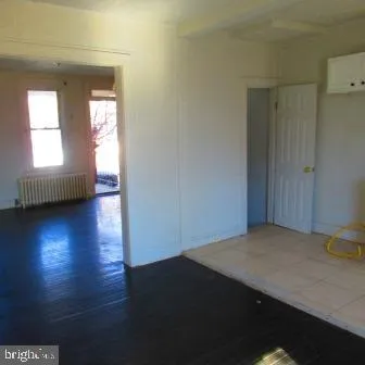 a view of a livingroom with wooden floor and a window