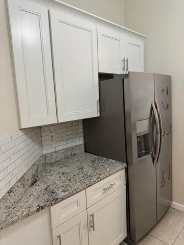a kitchen with granite countertop a refrigerator and a sink