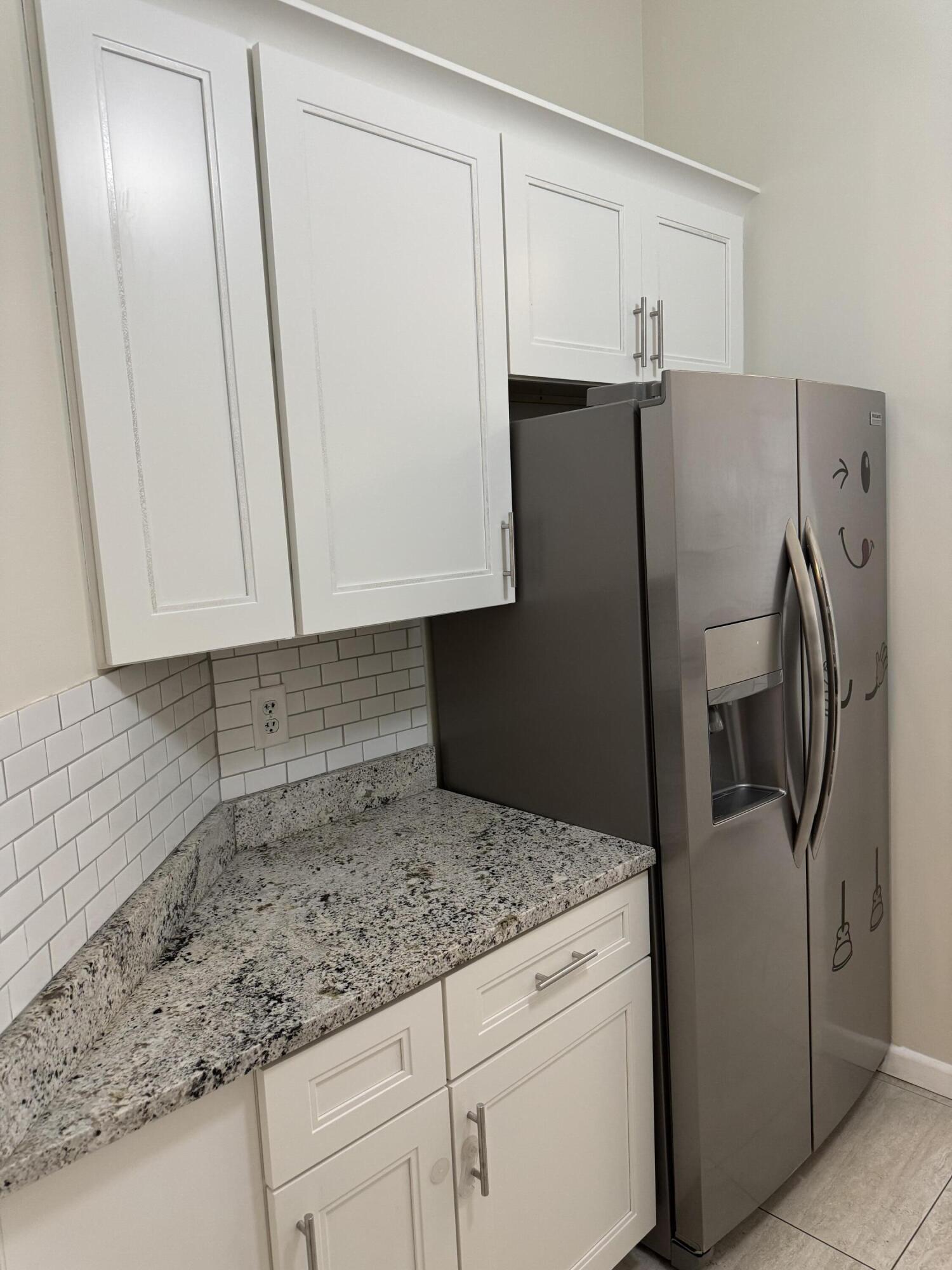 9777 Nickels Boulevard, Unit 705 Boynton Beach, FL 33436 - Photo 12 of 41 a kitchen with granite countertop a refrigerator and a sink
