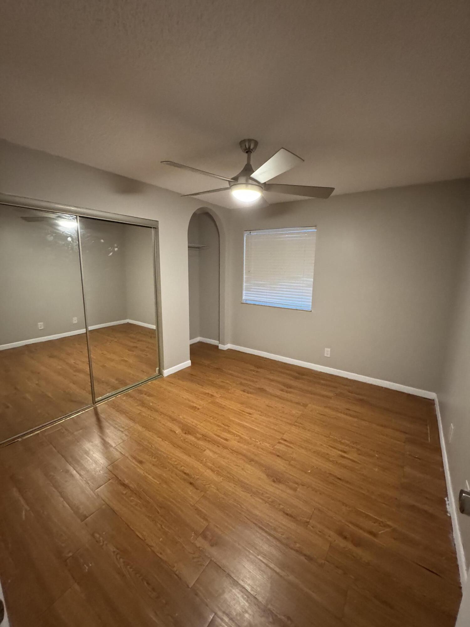 9777 Nickels Boulevard, Unit 705 Boynton Beach, FL 33436 - Photo 19 of 41 an empty room with wooden floor fan and windows