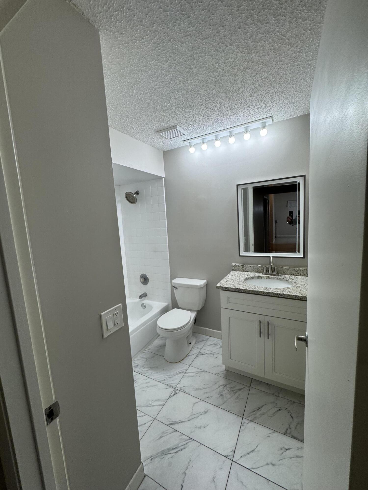 9777 Nickels Boulevard, Unit 705 Boynton Beach, FL 33436 - Photo 20 of 41 a bathroom with a toilet sink and mirror