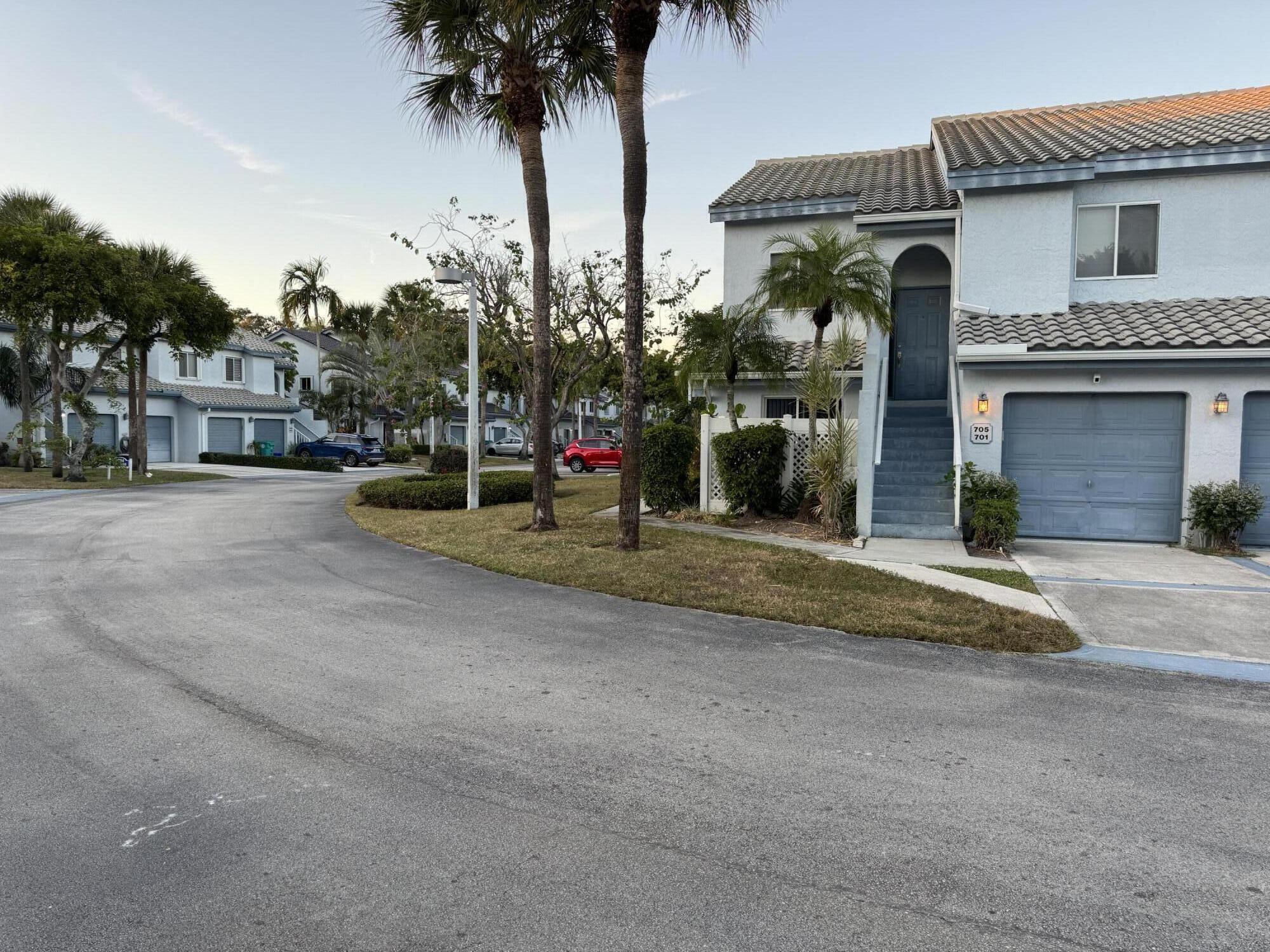 9777 Nickels Boulevard, Unit 705 Boynton Beach, FL 33436 - Photo 2 of 41 a view of a house with palm trees and a small yard