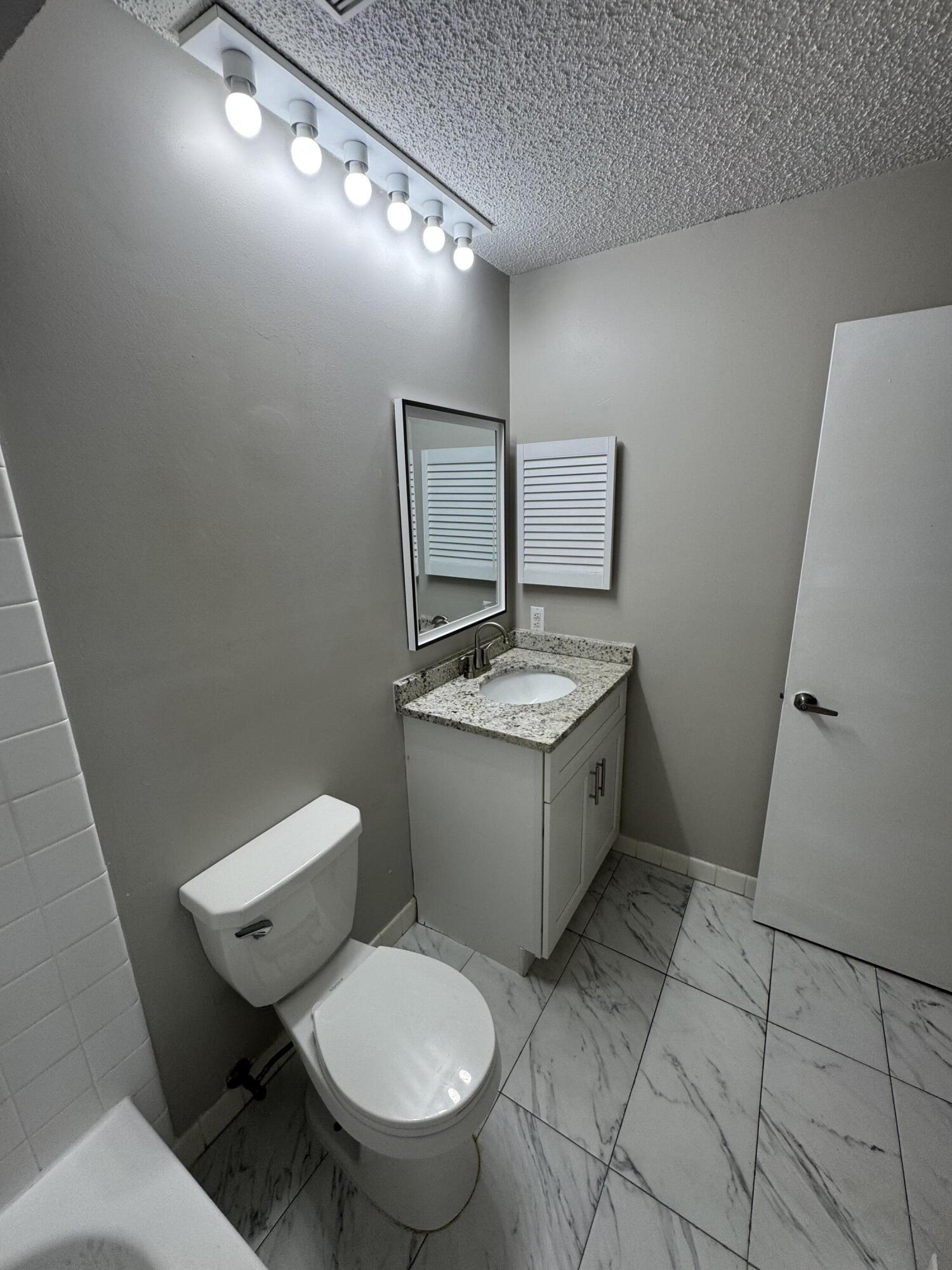9777 Nickels Boulevard, Unit 705 Boynton Beach, FL 33436 - Photo 21 of 41 a bathroom with a toilet sink and mirror